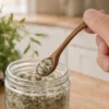 Handgefertigter Gewürzlöffel aus Kirschholz schöpft Kräutersalz aus einem Glas